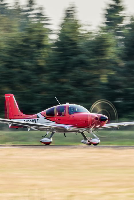 A red Cirrus SR22T departing an airport